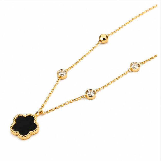 Left angled perspective shot of Zafiroon tarnish free gold chain necklace highlighting cz crystal stations and black enamel clover charm.