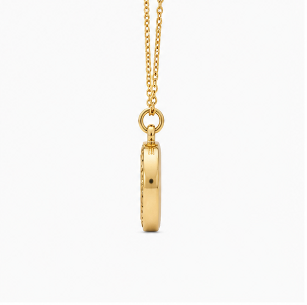Vertical side profile shot of Zafiroon gold oval pendant hanging from a delicate link chain to display its sleek geometric thickness.