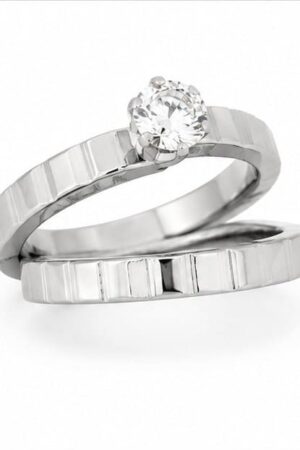 Silver polished stainless steel matching couple rings set displaying a geometric textured pattern and a round solitaire crystal on a white background