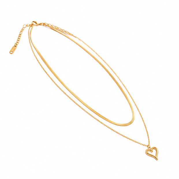 High angle right side view of a tarnish free gold multi strand necklace featuring a flat herringbone layer and heart outline charm.
