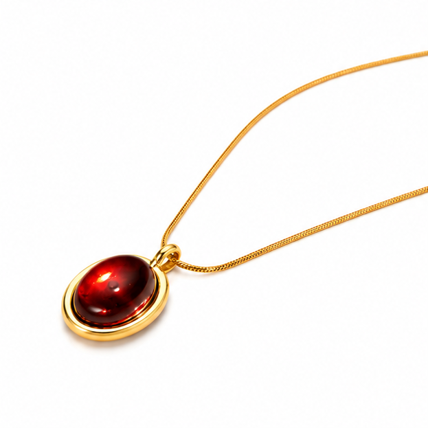 Left angled macro view of Zafiroon tarnish free gold snake chain necklace featuring a glossy oval red stone pendant.