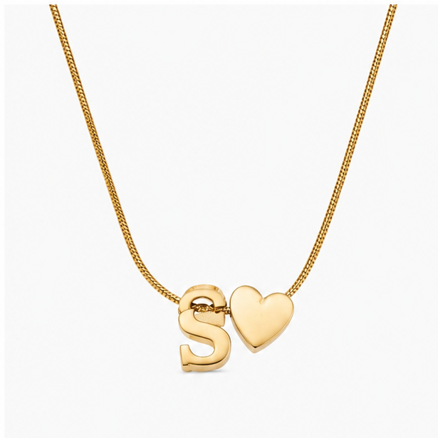 Gold plated stainless steel snake chain necklace featuring a chunky alphabet initial S charm and a smooth puff heart pendant on a clean white background