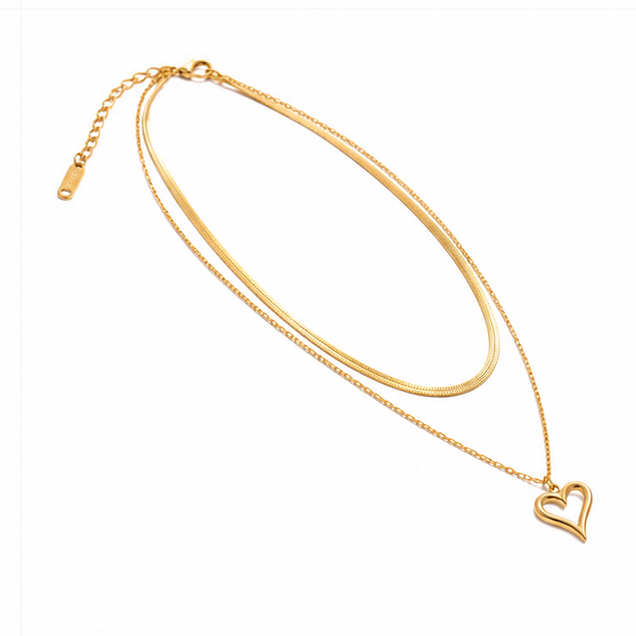Low angle dynamic studio presentation of a polished 18k gold plated hollow love heart pendant necklace on a white background.