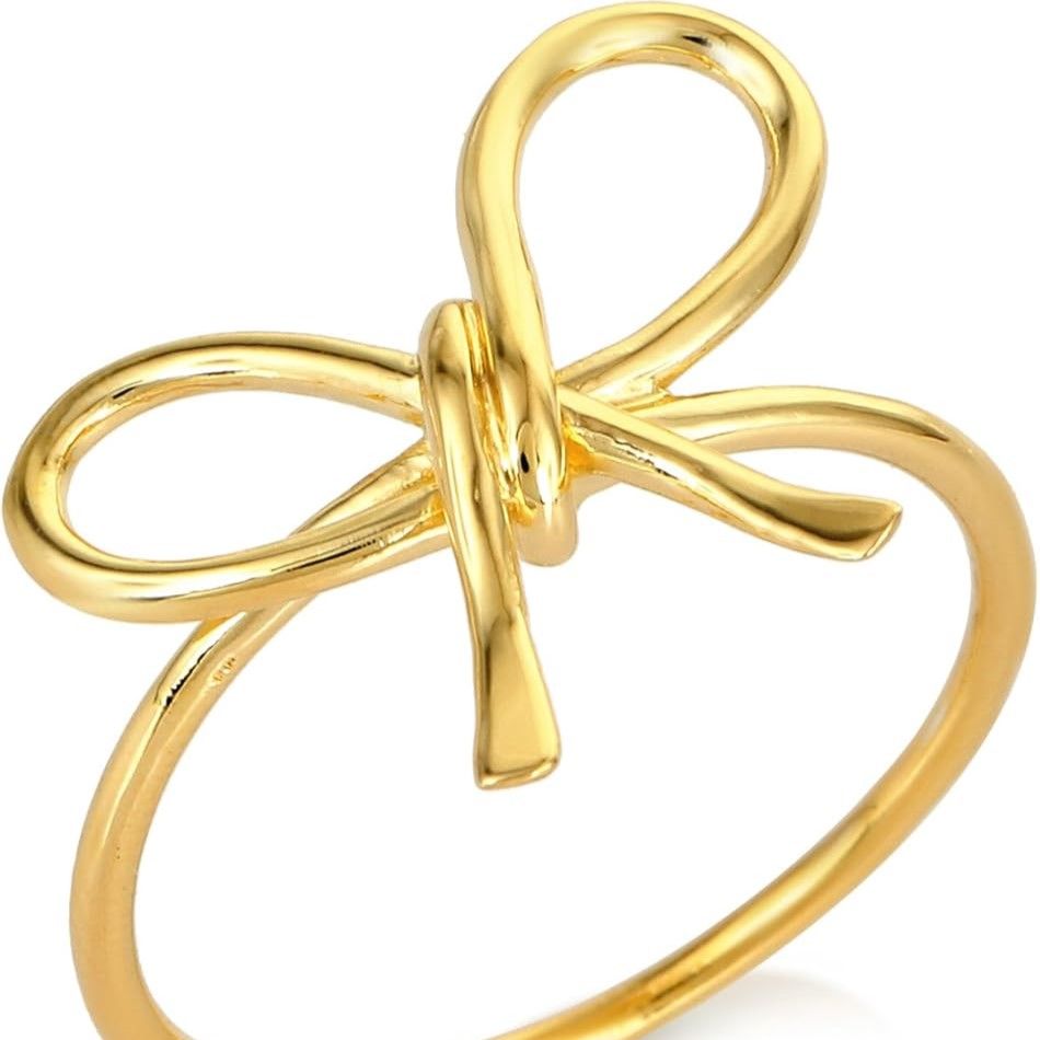 Gold plated stainless steel slim dainty ring featuring a central fluid metallic bow knot on a clean light background